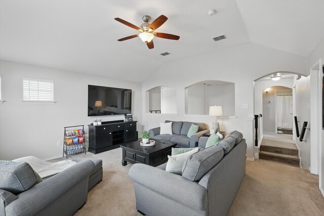 living area featuring arched walkways, a ceiling fan, lofted ceiling, and visible vents