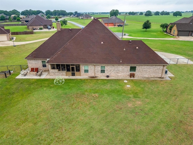 back of property featuring fence, roof with shingles, a chimney, a lawn, and a patio