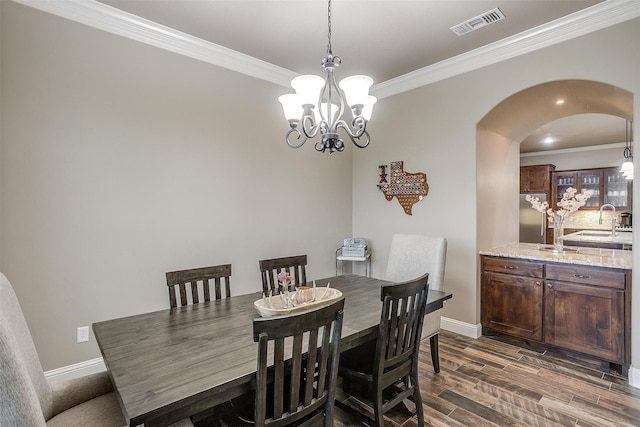 dining space featuring crown molding, arched walkways, baseboards, and visible vents
