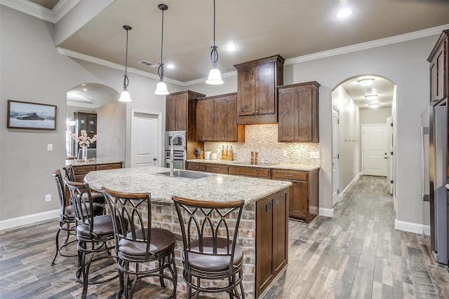 kitchen with baseboards, arched walkways, and dark wood-type flooring