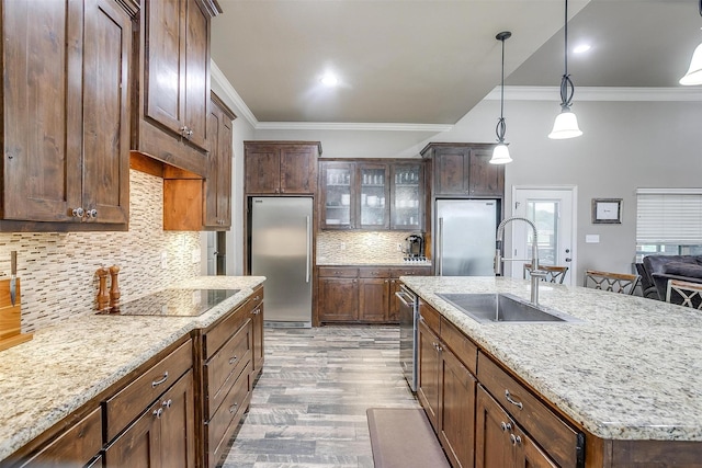 kitchen featuring a sink, appliances with stainless steel finishes, wood finished floors, and ornamental molding