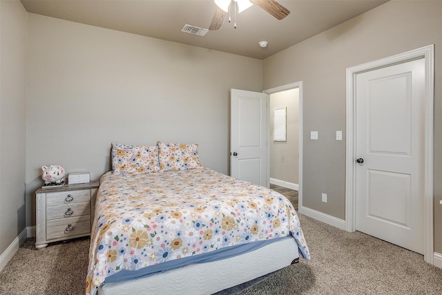 carpeted bedroom featuring baseboards, a ceiling fan, and visible vents