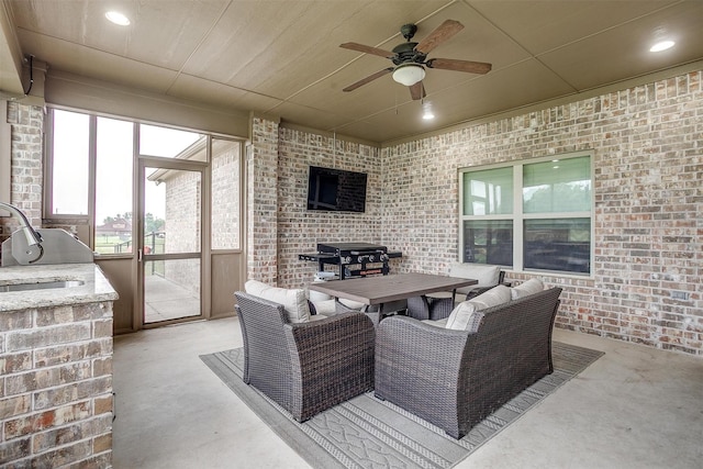 view of patio with ceiling fan, a sink, and outdoor dining space