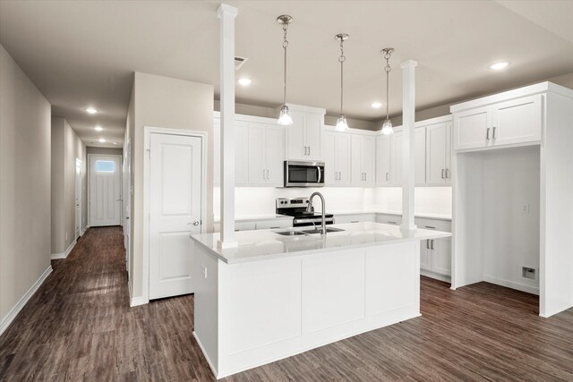 kitchen with white cabinets, an island with sink, stainless steel appliances, recessed lighting, and dark wood-style floors