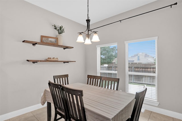dining room with baseboards, a notable chandelier, and light tile patterned flooring