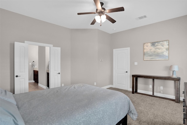 bedroom with baseboards, connected bathroom, visible vents, and a ceiling fan