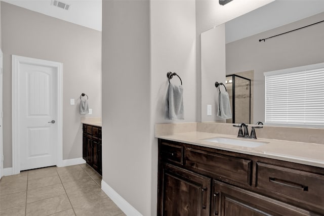 full bath featuring vanity, visible vents, tile patterned floors, a shower stall, and baseboards
