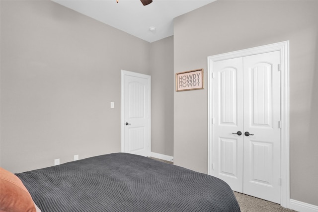 carpeted bedroom featuring ceiling fan, baseboards, and a closet