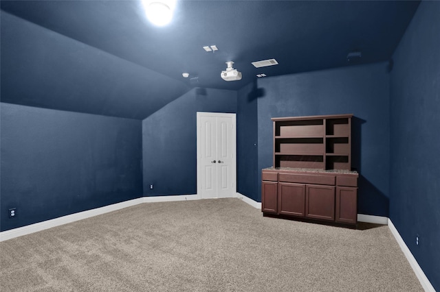 additional living space featuring lofted ceiling, carpet flooring, visible vents, and baseboards
