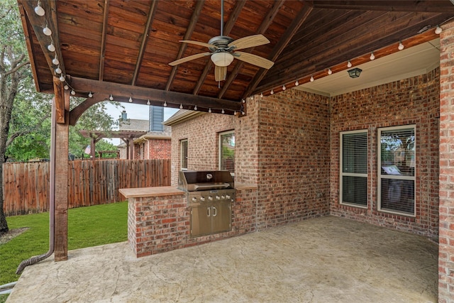 view of patio / terrace featuring exterior kitchen, a grill, a ceiling fan, and a fenced backyard