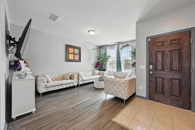 living area featuring visible vents and wood finished floors