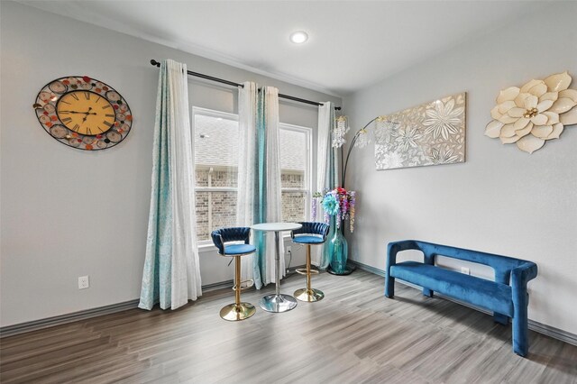 sitting room with baseboards and wood finished floors