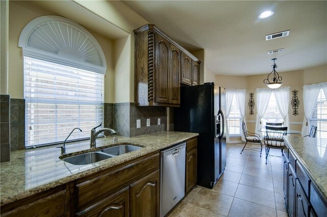 1290 Polo Heights Dr, Frisco, TX 75033 - kitchen with hanging light fixtures, light stone counters, a sink, dishwasher, and visible vents