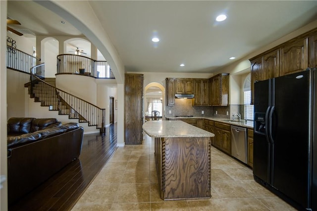 1290 Polo Heights Dr, Frisco, TX 75033 - kitchen featuring ceiling fan, a center island, arched walkways, dishwasher, and black fridge