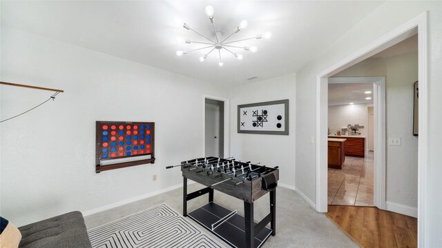 recreation room featuring baseboards and a notable chandelier