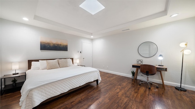 bedroom with a raised ceiling, recessed lighting, wood finished floors, and visible vents