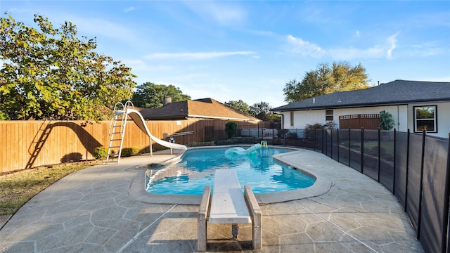 view of swimming pool with a fenced in pool, a water slide, a fenced backyard, and a patio area