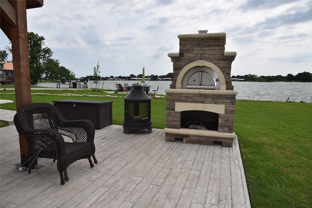 view of patio / terrace with an outdoor stone fireplace and a water view