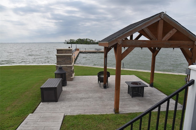 surrounding community with a water view, a yard, and a fire pit