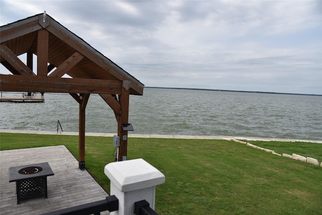 exterior space featuring a water view and a fire pit