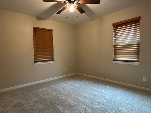 unfurnished room featuring carpet floors, baseboards, and ceiling fan