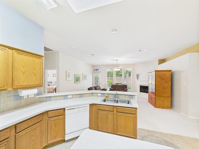kitchen featuring light countertops, open floor plan, a sink, and dishwasher