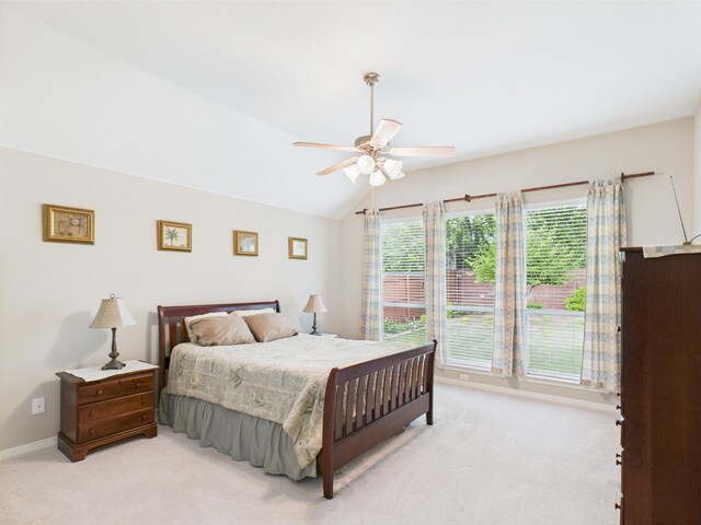 bedroom featuring baseboards, ceiling fan, light carpet, and vaulted ceiling