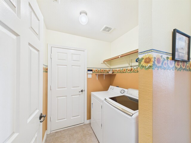laundry room with laundry area, visible vents, light tile patterned flooring, baseboards, and washer and clothes dryer