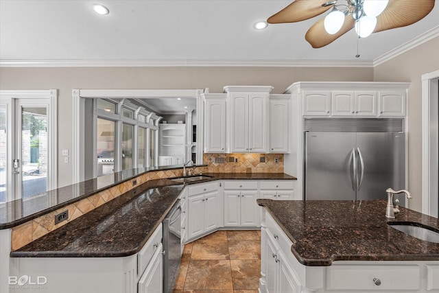 11 Chapel Creek Ln, Shreveport, LA 71106 - kitchen with stainless steel appliances, a sink, tasteful backsplash, ornamental molding, and white cabinetry