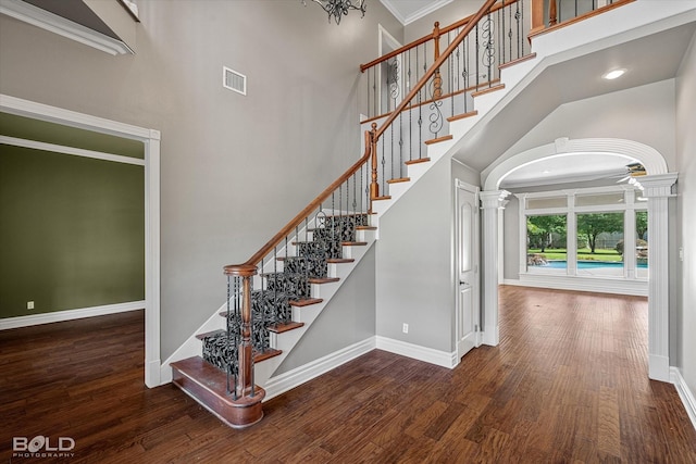 11 Chapel Creek Ln, Shreveport, LA 71106 - staircase with a high ceiling, ornate columns, baseboards, arched walkways, and wood finished floors
