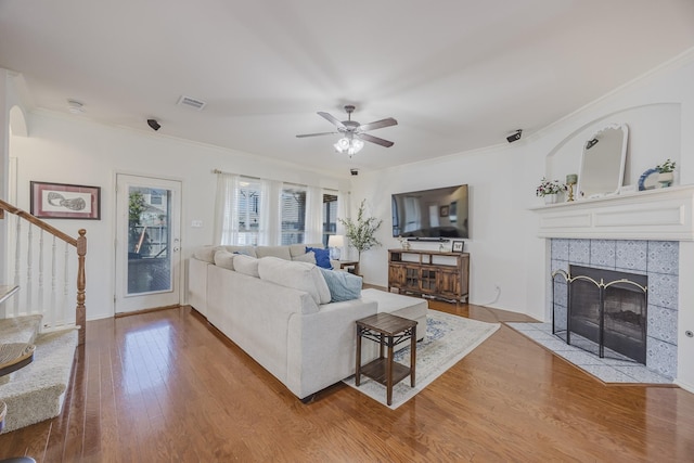 3949 Sunnygate Dr, Fort Worth, TX 76262 - living area with stairs, crown molding, wood finished floors, a tiled fireplace, and ceiling fan