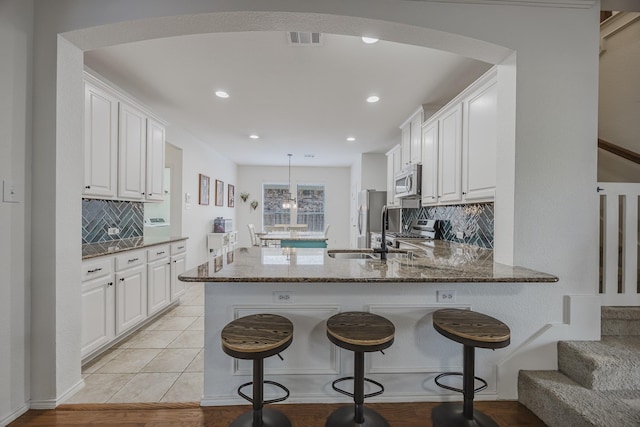3949 Sunnygate Dr, Fort Worth, TX 76262 - kitchen featuring stainless steel appliances, dark stone counters, white cabinets, and recessed lighting