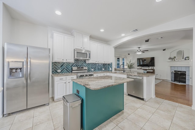 3949 Sunnygate Dr, Fort Worth, TX 76262 - kitchen featuring stainless steel appliances, open floor plan, ceiling fan, a peninsula, and light tile patterned floors