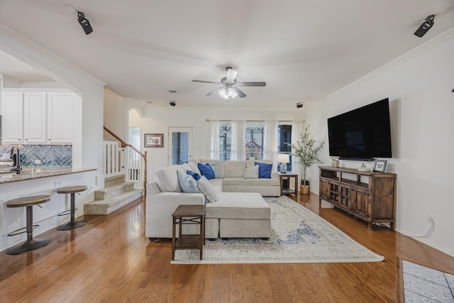 3949 Sunnygate Dr, Fort Worth, TX 76262 - living room with a ceiling fan, stairs, arched walkways, wood finished floors, and ornamental molding