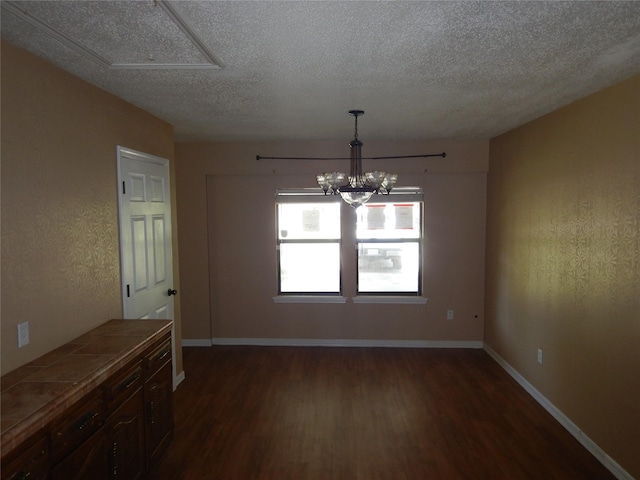 8157 Hobbs Dr, Shreveport, LA 71129 - unfurnished dining area with dark wood-type flooring, a textured ceiling, baseboards, and an inviting chandelier