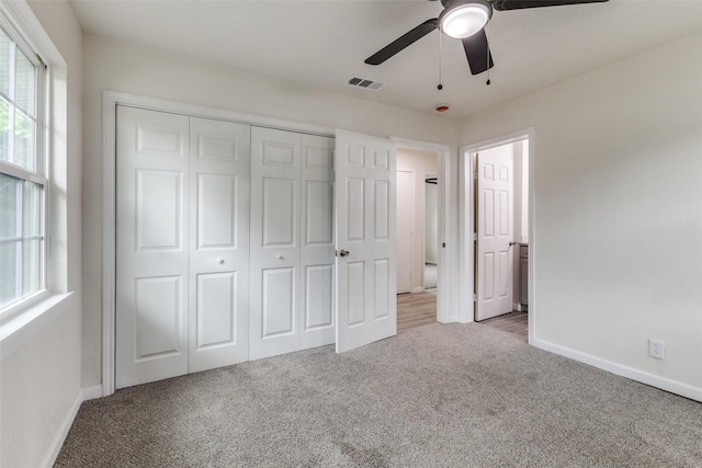unfurnished bedroom featuring visible vents, carpet flooring, baseboards, and a closet