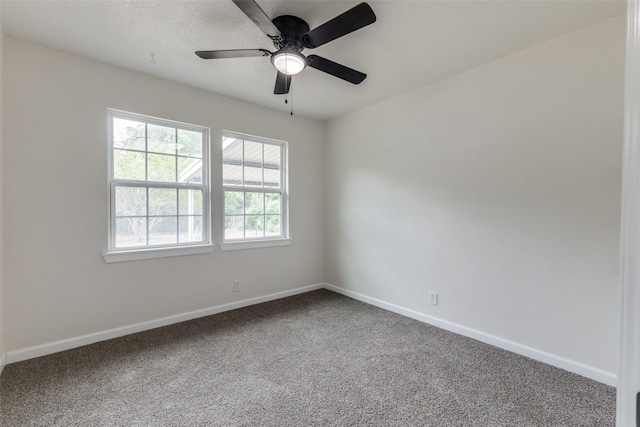carpeted spare room featuring baseboards and ceiling fan
