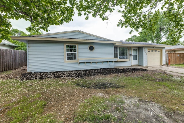 view of front of home with fence, driveway, and a garage