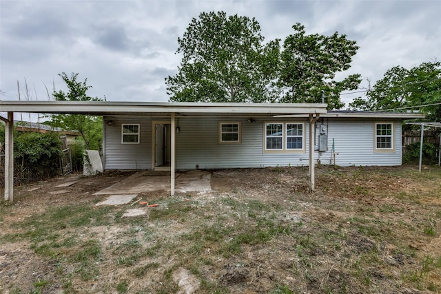 back of property featuring fence and an attached carport