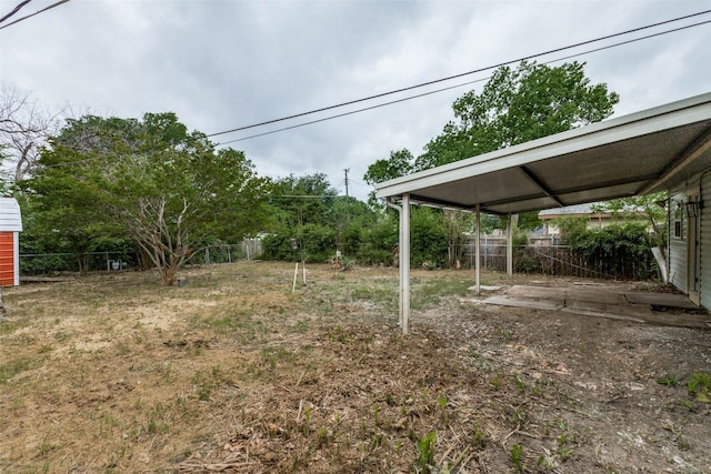 view of yard featuring fence and a carport