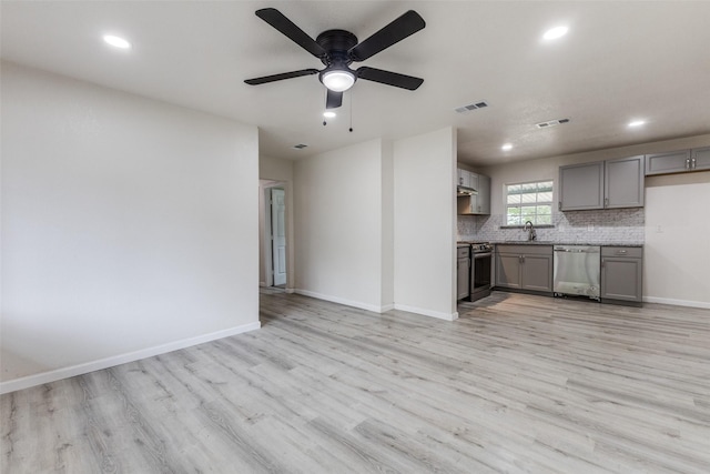 unfurnished living room with visible vents, a sink, and light wood finished floors