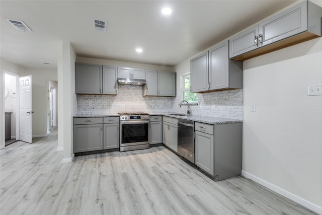 kitchen with visible vents, under cabinet range hood, gray cabinetry, and stainless steel appliances