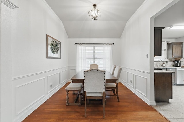 4610 Bluebird Ln, Mansfield, TX 76063 - dining area featuring lofted ceiling, a decorative wall, wainscoting, crown molding, and wood finished floors