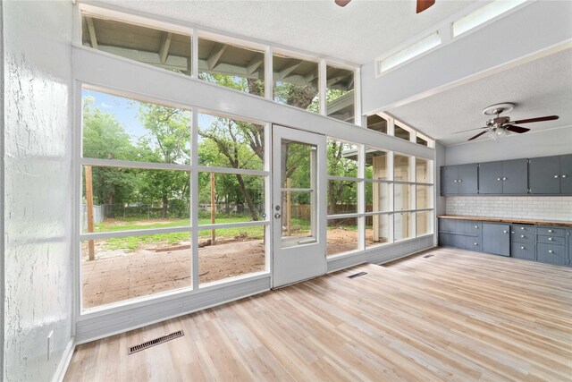 unfurnished sunroom featuring a ceiling fan and visible vents