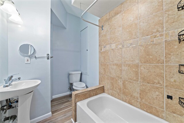 bathroom with toilet, baseboards, and wood finished floors