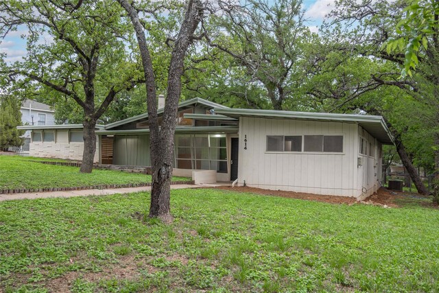 view of front of property with a sunroom and a front lawn