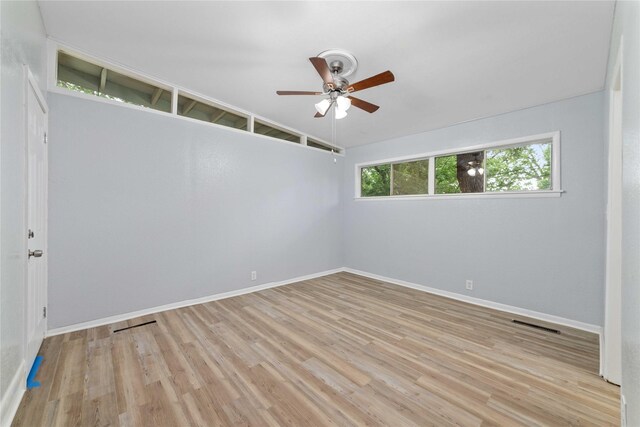 spare room featuring baseboards, ceiling fan, wood finished floors, and a healthy amount of sunlight