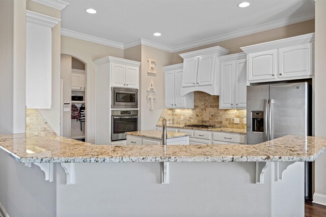 kitchen with recessed lighting, decorative backsplash, appliances with stainless steel finishes, and light stone counters