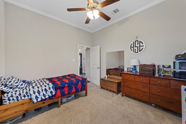 bedroom featuring ornamental molding, a ceiling fan, light colored carpet, and visible vents