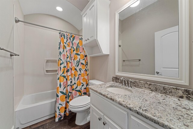 full bath with toilet, shower / bath combo with shower curtain, wood finished floors, and vanity